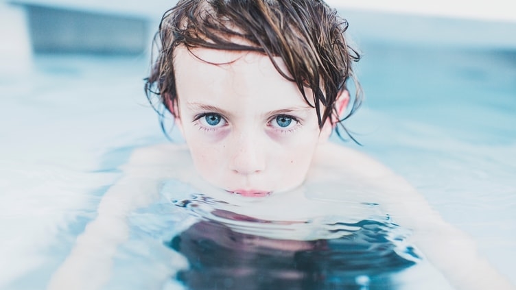 水にあごまで潜っている少年